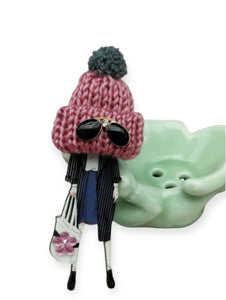 Spilla con modella fashion e cappellino in lana rosa con occhiali da sole
